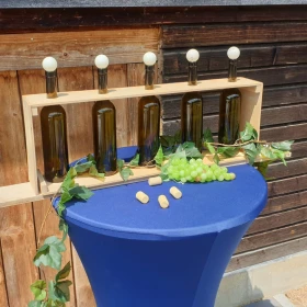 Weinflaschen in einem Holzkasten auf einem Stehtisch