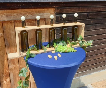 Weinflaschen in einem Holzkasten auf einem Stehtisch