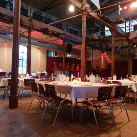 EVINTA_Eventlocation_Bild01 gedeckte Tische mit Stühlen in einer Location