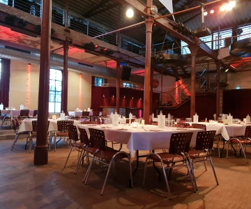 EVINTA_Eventlocation_Bild01 gedeckte Tische mit Stühlen in einer Location