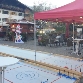 zwei Eisstockbahnen mit einem roten Pavillion