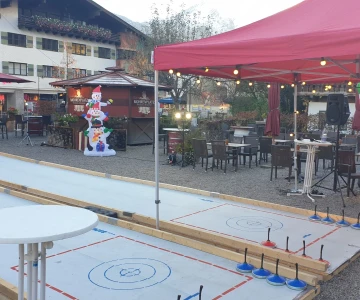 zwei Eisstockbahnen mit einem roten Pavillion