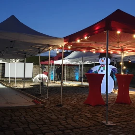 eine Eisstockbahn unter Pavillions mit Lichterketten