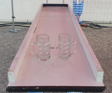 EVINTA_Oktoberfest-Spiele_Bild 01 Krugschieben in einem weißen Pavillons mit Oktoberfest-Dekoration