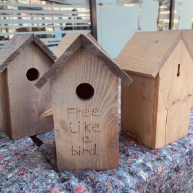 Vogelhaus aus Holz mit der Aufschrift "Fee like a bird"