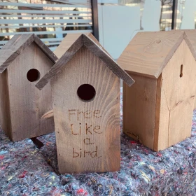 Vogelhaus aus Holz mit der Aufschrift "Fee like a bird"
