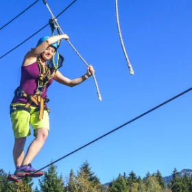 Frau balanciert auf Hochseil