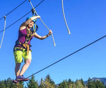 Frau balanciert auf Hochseil