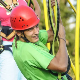 Mann hält sich im Kletternetz fest