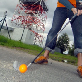 EVINTA_Crossgolf_Bild02 Frau schlägt orangenen Golfball ab