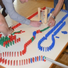 Leute bauen mit Dominosteine auf