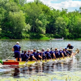 Menschen in blauer Kleidung beim Drachenbootfahren