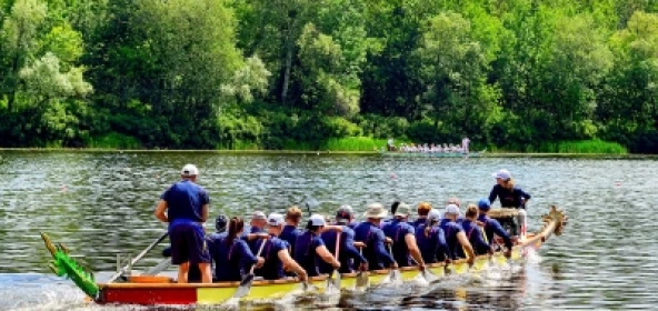 Menschen in blauer Kleidung beim Drachenbootfahren