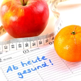 EVINTA_Firmen-Gesundheitstag_Bild01 Apfel und Mandarine, Maßband und Zettel mit Aufschrift - Ab heute Gesund!