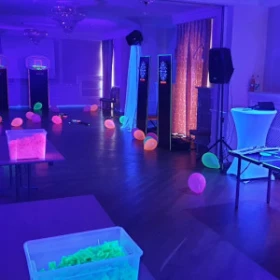 dunkler Raum mit pinkt leuchtenden Spielstationen