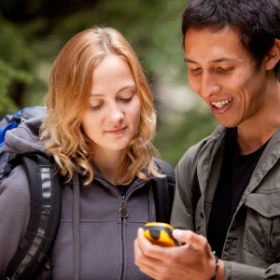 Mann und Frau schauen auf ein GPS Gerät