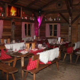 festlich geschmückte Tafel in einer Holzhütte