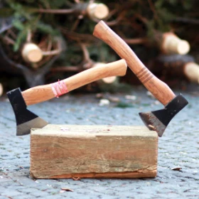 zwei Äxte stecken in einem Holzklotz