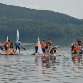 Gruppen mit dem gebauten Floß auf dem Wasser