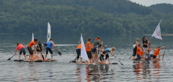 Gruppen mit dem gebauten Floß auf dem Wasser