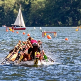 Drachenboot in der Frontansicht, in Hintergrund ein Segelboot
