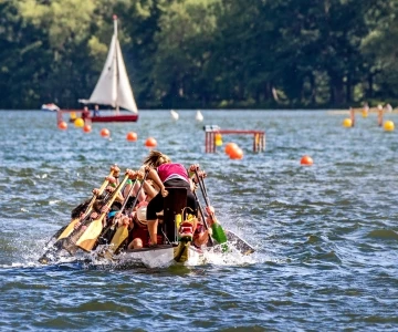 Drachenboot in der Frontansicht, in Hintergrund ein Segelboot
