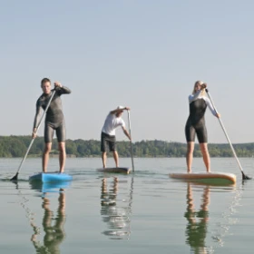 drei Personen stehend auf dem Board