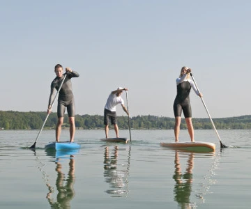 drei Personen stehend auf dem Board