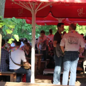 Leute unter Schirmen auf einer Terrasse