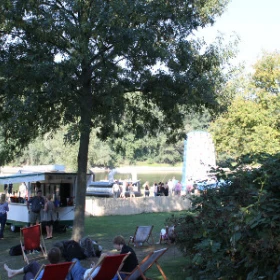 Leute in Liegestühlen auf einer Wiese