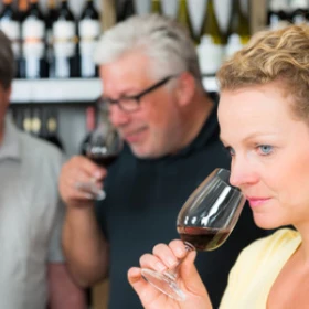 Personen riechen am Weinglas