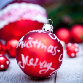 rote Weihnachtskugel mit Aufschrift Merry Christmas