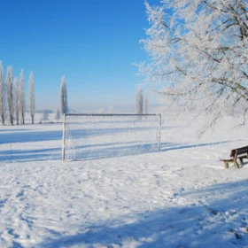 verschneites Fußballfeld mit Tor im Schnee