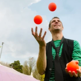 Jongleur mit roten Bällen