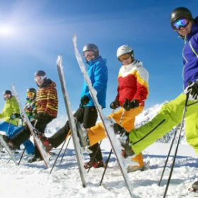 Skifahrer stehen in einer Reihe, bunte Skikleidung