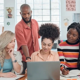 Gruppe schaut gespannt auf einen Laptop