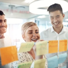 Gruppe schreibt Noitzen auf verschiedene Klebezettel