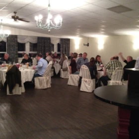 Firmenfeier in einem Tagungsraum, weiße Tische und Stühle