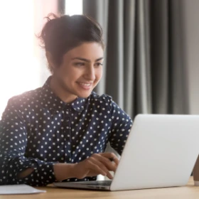 Frau sitzt vor ihrem Laptop und hört zu
