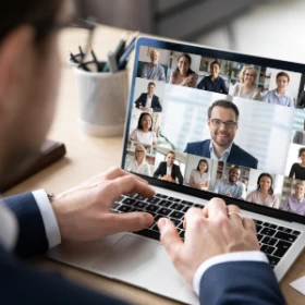 ein aufgeklappter Laptop auf dem eine Konferenz läuft