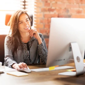 Frau sitzt grübelnd vor ihrem Rechner