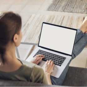 Frau sitzt auf einem Sofa mit ihrem Laptop