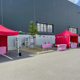 Rote Pavillons vor einer Fabrikhalle