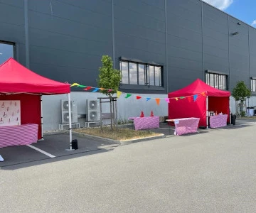 Rote Pavillons vor einer Fabrikhalle