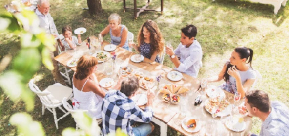 Personen sitzen an einem Tisch und essen gemütlich
