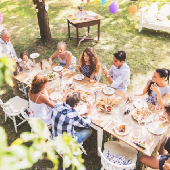 Personen sitzen an einem Tisch und essen gemütlich