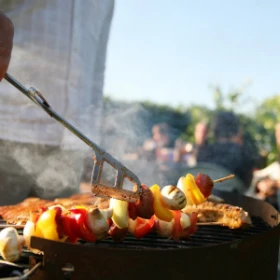 es werden verschiedene Gemüsesorten und Fleisch auf einem Grill gebraten