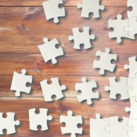 weiße Puzzleteile auf einem Holztisch