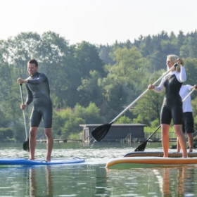 Gruppe macht gemeinsam Stand Up Paddling