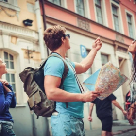 Mann steht in einer Stadt und hält eine Stadtkarte in der Hand
